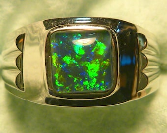 May include: A silver ring with a square-shaped green and blue opal gemstone set in the center.