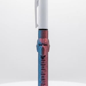 Peut inclure: Un stylo à encre multicolore doté d'une partie supérieure blanche avec des boutons rétractables rouge, bleu et vert. Le corps inférieur présente une finition métallique irisée violette et bleue avec un masque sculpté et le mot DEADPOOL en relief.