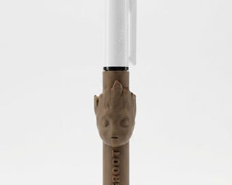 May include: A multi-color retractable ballpoint pen featuring a white upper barrel with a pocket clip and a brown lower barrel. The pen includes a sculpted brown figure of a character head and the text I AM GROOT embossed on the lower section.