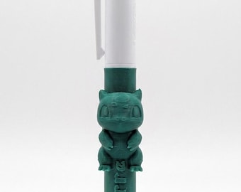 May include: A multi-color retractable ballpoint pen featuring a white top section with blue, green, and red ink selectors. The lower barrel is dark green, textured, and adorned with a sculpted figure of a creature and the text Bulbizarre.