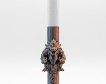 May include: A multi-color ballpoint pen featuring a white top section with four retractable ink color selectors and a metallic bronze-colored lower barrel. A 3D-printed figure of Bowser is attached to the barrel with the name BOWSER embossed below.