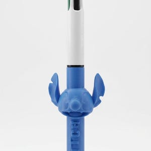 Peut inclure: Un stylo à bille multicolore doté d'un corps supérieur blanc avec un mécanisme de sélection sur le dessus et d'un corps inférieur bleu. Le stylo comprend un embout bleu moulé représentant Stitch avec ses oreilles et le mot STITCH en relief.