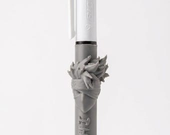 May include: A multi-color ballpoint pen featuring a white top section with a pocket clip and three colored ink selectors. The lower gray barrel is adorned with a sculpted character head and the text KAKASHI embossed vertically along the side.