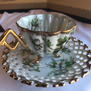 May include: A set of three ceramic mugs with a speckled, matte finish. The mugs are in shades of cream, light gray, and dark gray. Each mug has a simple, minimalist design and a rounded handle.