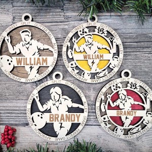 May include: Four circular wooden ornaments featuring laser-cut bowling designs. Two ornaments display the name WILLIAM and two display BRANDY. The outer rings are engraved with bowling terms like STRIKE, TURKEY, and SPLIT.