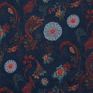 Könnte beinhalten: Ein dunkelblauer Stoff mit einem komplizierten Stickmuster aus stilisierten Blumenmotiven, kreisförmigen geometrischen Formen mit roten Zentren und wirbelnden organischen Formen in rostorangen, türkisfarbenen und hellblauen Garnen.