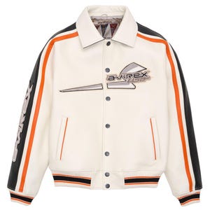 May include: A white leather jacket featuring black and orange stripes along the sleeves, a button-front closure, and the text Avirex USA embroidered on the chest and sleeve. The jacket includes a ribbed hem and cuffs with black and orange accents.