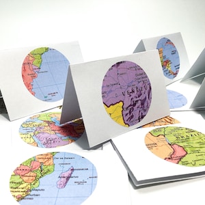 May include: A set of ten blank greeting cards with a world map design. Each card features a different continent in a colorful, vintage style.