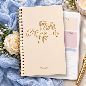 May include: A spiral-bound Bible study planner with a cream-colored cover featuring gold floral line art and the text "Bible study" and "Planner". The interior page shows sections labeled "Prayer", "Highlights", and "Notes" with lined spaces.