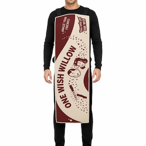 K&ouml;nnte beinhalten: Ein rechteckiges Kost&uuml;mschild in Creme und Kastanienbraun mit dem Text ONE WISH WILLOW, AMAZE YOUR FRIENDS! und You only get ONE WISH. Das Design enth&auml;lt Illustrationen von zwei Gesichtern und einem W&uuml;nscheknochen mit dem Wort CRACK.