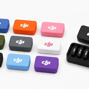 May include: A collection of rectangular DJI branded protective cases in various colors including blue, orange, pink, olive green, gray, white, black, light blue, and purple, alongside an open black case containing four ND camera filters.