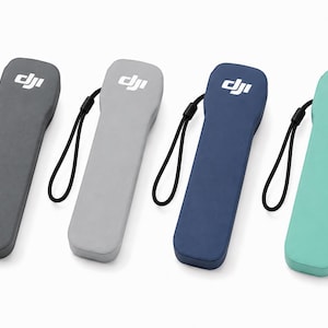 Puede incluir: Cuatro mandos a distancia portátiles de la marca DJI en gris oscuro, gris claro, azul marino y verde menta. Cada dispositivo rectangular presenta un logotipo DJI blanco en la parte superior y una correa negra en el lateral, en fila.