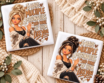 May include: Two square white ceramic coasters featuring a cartoon illustration of a person with a high bun hairstyle, wearing a black top and a beige cardigan with leopard print accents, with the text I HAVE MULTIPLE PERSONALITIES AND NONE OF THEM LIKE YOU.