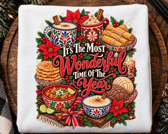 May include: A white sweatshirt featuring a colorful graphic with the text It's The Most Wonderful Time Of The Year, surrounded by illustrations of mugs, cinnamon sticks, poinsettias, bowls of food, and sweet breads.