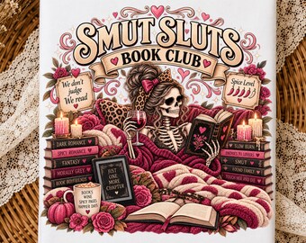 May include: A white rectangular print featuring a skeleton reading a book while holding a wine glass. The text reads SMUT SLUTS BOOK CLUB, We don't judge We read, Spice Level, JUST ONE MORE CHAPTER, and BOOKS WINE SPICY PAGES HAPPIER DAYS.