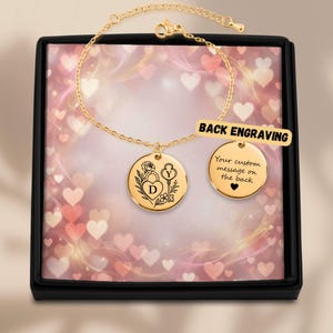 Puede incluir: Una pulsera de cadena en tono dorado con dos dijes circulares. Un dije muestra un candado en forma de corazón grabado con la letra D y una llave con la letra Y. El segundo dije presenta el texto Your custom message on the back y un corazón.