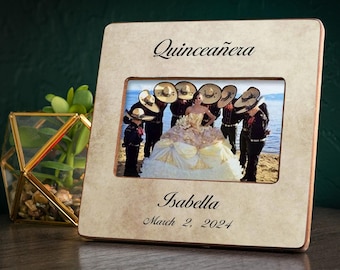 May include: A wooden picture frame with a beige background and a photo of a quinceañera with her court. The frame is engraved with the text "Quinceañera", "Isabella", and "March 2, 2024".