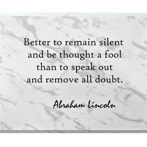 May include: A white marble plaque with a black quote that reads "Better to remain silent and be thought a fool than to speak out and remove all doubt." The quote is attributed to Abraham Lincoln.