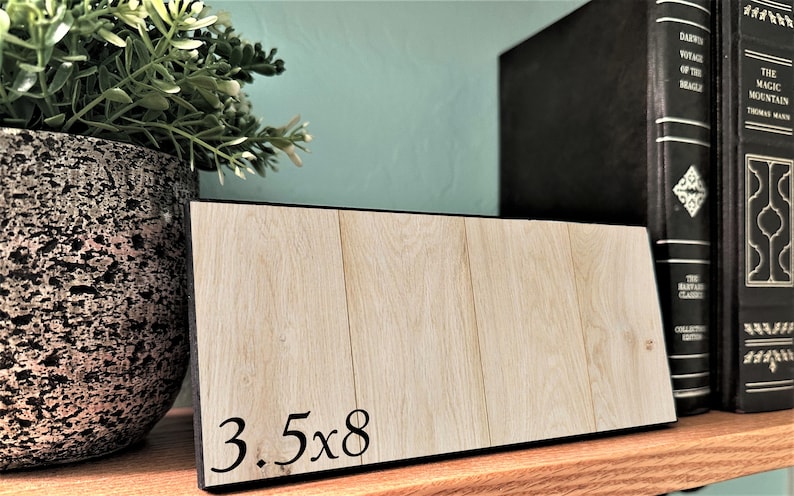 May include: A wooden sign with black trim and the text "3.5x8" printed on it.