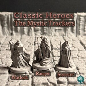 Könnte beinhalten: Drei unbemalte graue Miniaturfiguren mit der Aufschrift Classic Heroes The Mystic Trackers. Die Figuren sind als Warlock, Ranger und Sorcerer gekennzeichnet. Jede Figur steht auf einem runden Sockel und zeigt detaillierte Roben, Accessoires und Waffen vor einem steinartigen Hintergrund.