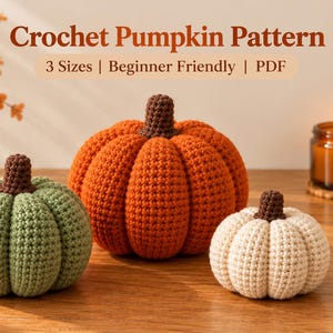Könnte beinhalten: Drei gehäkelte Kürbisse in Salbeigrün, Orange und Creme, jeweils mit einem braunen Stiel. Der Text Crochet Pumpkin Pattern 3 Sizes | Beginner Friendly | PDF steht über den Kürbissen, die auf einer Holzoberfläche angeordnet sind.