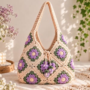 Könnte beinhalten: Eine Häkeltasche aus zusammengesetzten Granny Squares mit Blumenmuster. Die Tasche ist überwiegend cremefarben mit violetten und gelben Blütenmitten, die von dunkelgrünen Blättern umgeben sind. Sie verfügt über einen Kordelzug mit Quasten.