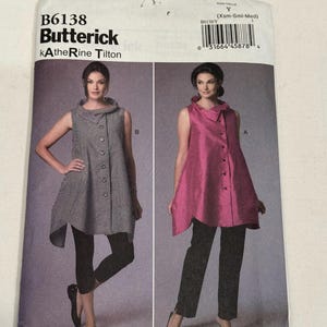 Peut inclure: Une enveloppe de patron de couture présentant deux hauts pour femmes. L'enveloppe est étiquetée "B6138 Butterick kAtheRine Tilton". Un haut est gris avec des boutons, l'autre est rose avec des boutons. La taille est Y (Xsm-Smi-Med).