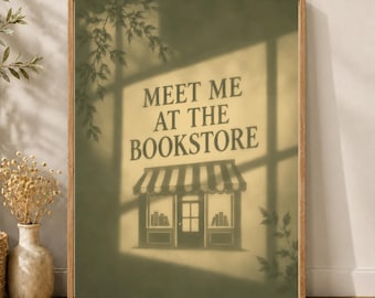 May include: A framed wall art print featuring a sage green background with a shadow overlay of tree branches. The centre displays the text MEET ME AT THE BOOKSTORE above a graphic illustration of a storefront with a striped awning and books.