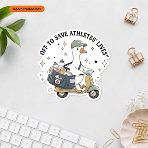 May include: A die-cut sticker featuring a white duck wearing a green baseball cap, riding a light green scooter. The duck carries a dark blue medical bag filled with supplies. The text reads OFF TO SAVE ATHLETES' LIVES with small star accents.