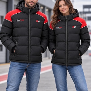 Op de afbeelding: Zwarte gewatteerde jassen met rode schouderpanelen, een capuchon en een ritssluiting aan de voorzijde. Op de borst staat de tekst RaceForge Sportswear en het RF-logo. De jassen worden gecombineerd met een blauwe spijkerbroek.