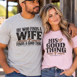 May include: A light gray t-shirt with black text reading HE WHO FINDS A WIFE FINDS A GOOD THING PROVERBS 18:22 and a pink t-shirt with black text reading HIS GOOD THING PROVERBS 18:22, both featuring a small brown cross and a heart graphic.