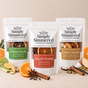 May include: Three white pouches of Simply Simmered potpourri blends labeled Citrus Fresh, Spiced Orange, and Golden Vanilla. Each pouch features a clear window displaying dried fruit, spices, and herbs, with text listing ingredients like orange, cinnamon, and vanilla.