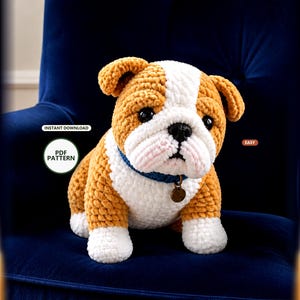 Peut inclure: Un jouet en peluche bouledogue au crochet fait de fil marron et blanc, avec des yeux noirs, un nez noir et un collier bleu avec une petite étiquette en métal. L'image contient le texte INSTANT DOWNLOAD, PDF PATTERN et EASY, pour un guide.