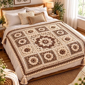 May include: A crochet blanket featuring a repeating square pattern with central floral motifs in shades of cream and brown. The blanket is finished with a decorative border and cream-colored tassels at the corners, laid flat over a white bedspread.