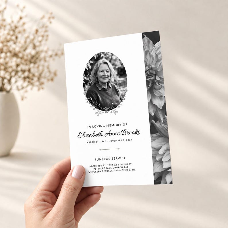 May include: A rectangular funeral program card featuring a black and white portrait of a person in an oval frame, floral border accents, and text reading In Loving Memory of Elizabeth Anne Brooks, March 14, 1942 - November 8, 2024, Funeral Service.