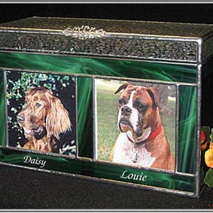 May include: A green stained glass box with two photo inserts. The photos show a red Irish Setter named Daisy and a brindle Boxer named Louie. The box has a silver metal frame and a decorative metal accent on the top.