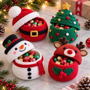 May include: Four round crochet containers with lids, each featuring a holiday theme: a red Santa suit, a green Christmas tree with a yellow star, a white snowman with a black hat, and a red reindeer with brown antlers and green holly leaves.