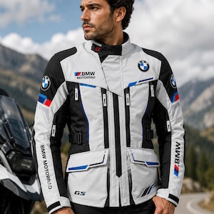 Könnte beinhalten: Eine hellgraue, schwarze und blaue Motorradjacke mit dem BMW Motorrad Logo auf Brust und Ärmeln sowie dem Schriftzug BMW Motorrad und GS auf der Vorderseite. Die Jacke verfügt über einen Stehkragen, mehrere Reißverschlusstaschen und verstellbare Riemen.