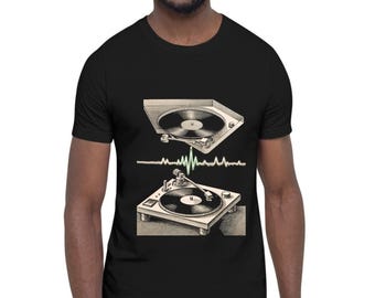 May include: A black short-sleeve t-shirt featuring a graphic print of two vintage turntables stacked vertically. Between the turntables is a horizontal light green sound wave line. The illustration is rendered in a detailed, sketch-like style.