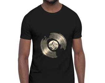 May include: A black short-sleeve t-shirt featuring a graphic print on the chest. The design depicts a stylized gold-toned vinyl record with a circular center illustration showing a detailed mountain landscape with trees and a peak.