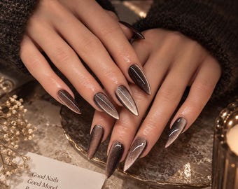 Uñas postizas estilo ojo de gato color marrón chocolate hechas a mano, con brillo metálico.
