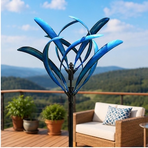 May include: A kinetic wind spinner sculpture featuring multiple curved, metallic blue blades arranged in a radial pattern. The sculpture is mounted on a central black metal pole, with the blades designed to rotate independently in the wind.