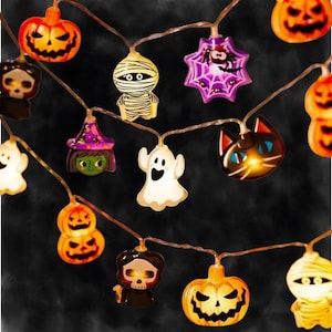May include: A string of LED Halloween lights featuring various illuminated figures including orange jack-o'-lanterns, a white mummy, a purple spider web with a spider, a witch, a white ghost, a black cat, and a skull character on a thin wire.