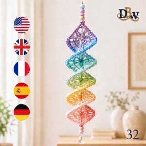 May include: A hanging spiral decoration made of five connected crochet granny squares in a rainbow gradient of purple, blue, green, yellow, and pink. The piece features wooden beads at the top and bottom, with a clear crystal drop at the base.