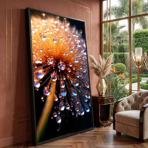 Peut inclure: Une grande œuvre d'art murale rectangulaire encadrée représentant une photographie macro d'une tête de pissenlit couverte de gouttelettes d'eau scintillantes, aux tons orange, or et noir profond sur fond sombre.