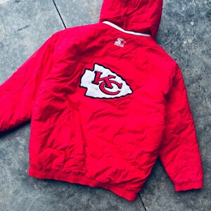 May include: Red Starter brand hooded jacket with a white and red Kansas City Chiefs logo on the back.