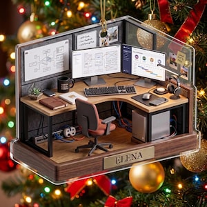 May include: A miniature office cubicle ornament featuring a wooden desk, two computer monitors with wireframe designs, a keyboard, a mouse, a black mug, a chair, and a silver tower computer. A gold plaque on the front displays the name ELENA.