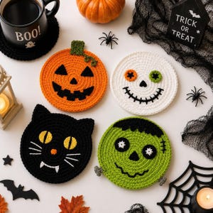 Puede incluir: Cuatro posavasos de ganchillo con diseños de Halloween: una calabaza naranja, una calavera blanca con ojos de colores, un gato negro con ojos amarillos y colmillos blancos, y un monstruo verde con pelo negro y pernos.