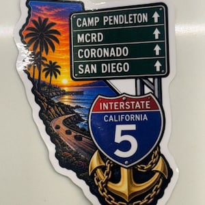May include: A die-cut sticker shaped like California featuring a coastal sunset, palm trees, and a highway. It includes a green road sign pointing to Camp Pendleton, MCRD, Coronado, and San Diego, plus an Interstate 5 shield and a gold anchor.