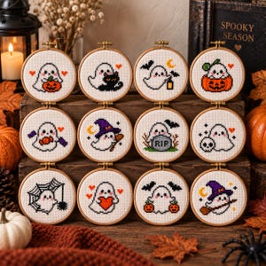 Puede incluir: Doce bastidores de bordado circulares de madera que contienen diseños de punto de cruz de fantasmas blancos en varias escenas temáticas de Halloween, incluyendo calabazas, murciélagos, un gato negro, una lápida, una calavera y un sombrero de bruja.